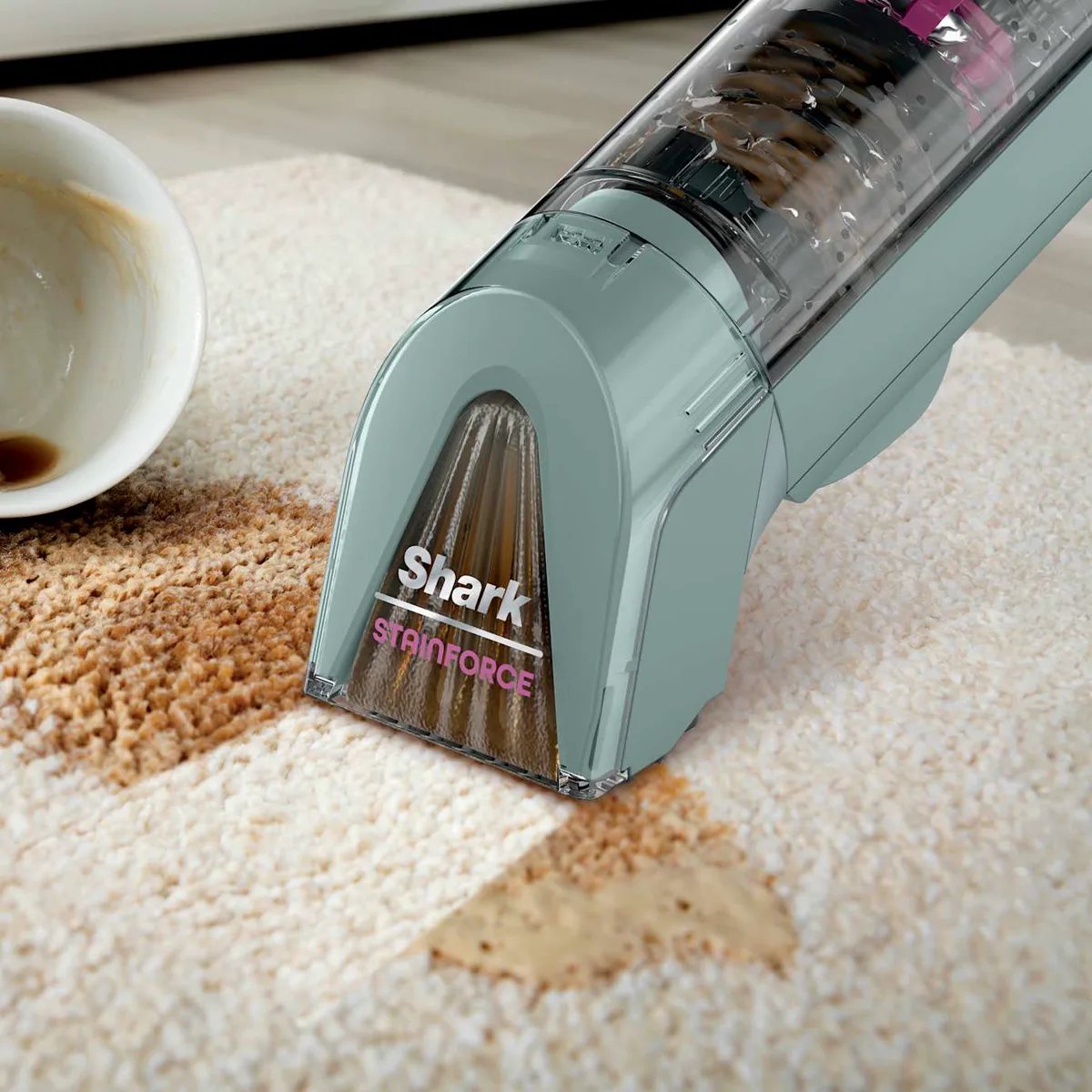 Cleaner lifting a coffee spill out of a cream rug